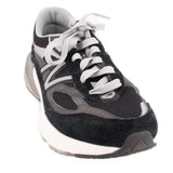 New Balance black and gray suede sneakers with mesh panels, white laces, and cushioned soles