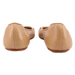 Tan leather flats with low heel and rounded back profile.