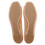 Tan leather flat soles with Coach logo and textured traction pads.