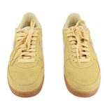 Pair of yellow suede Nike sneakers shown from above with lace-up tops