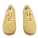 Pair of yellow suede Nike sneakers shown from above with lace-up tops