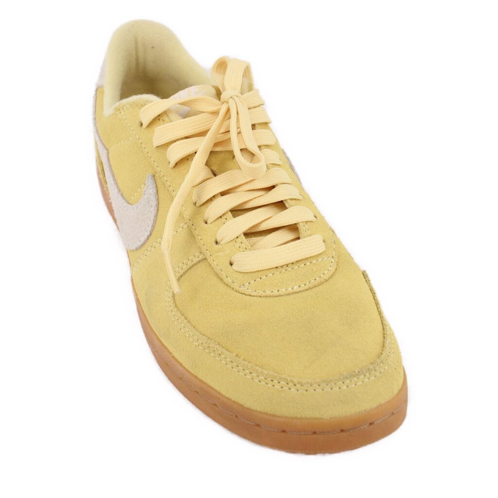 Yellow suede Nike sneakers with lace-up front and white swoosh accents