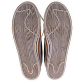 Pair of Nike sneakers showing textured herringbone rubber outsoles