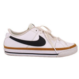Side view of white Nike leather sneaker with black Swoosh and tan midsole stripe