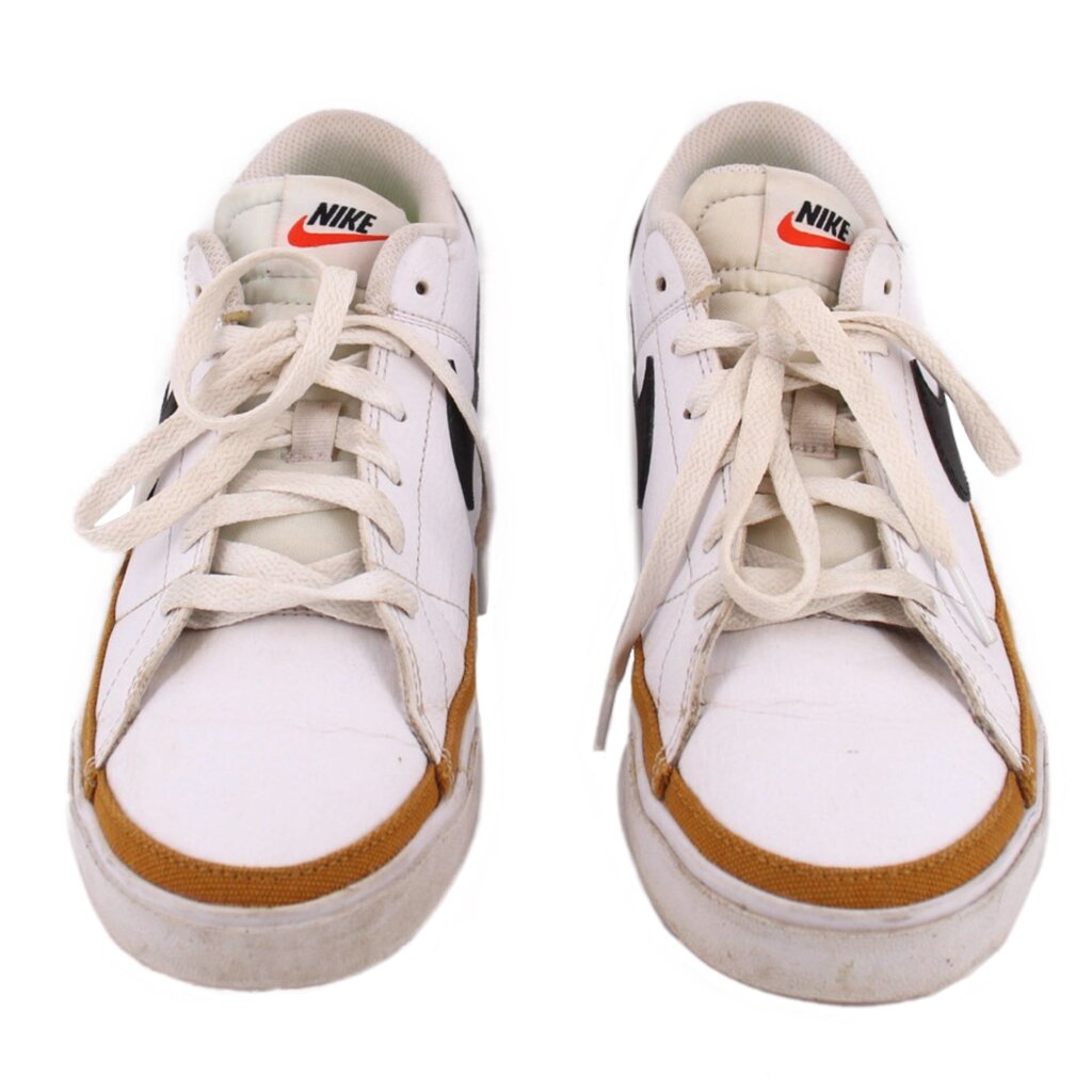 Pair of white Nike leather sneakers viewed from the front, with tan toe trim
