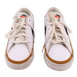 Pair of white Nike leather sneakers viewed from the front, with tan toe trim