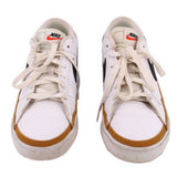 Pair of white Nike leather sneakers viewed from the front, with tan toe trim