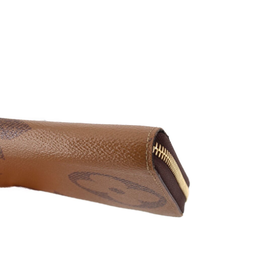 Corner close-up of brown monogram zip wallet with gold zipper trim