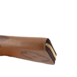 Corner close-up of brown monogram zip wallet with gold zipper trim