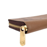Close-up of gold zipper pull on brown monogram zip wallet