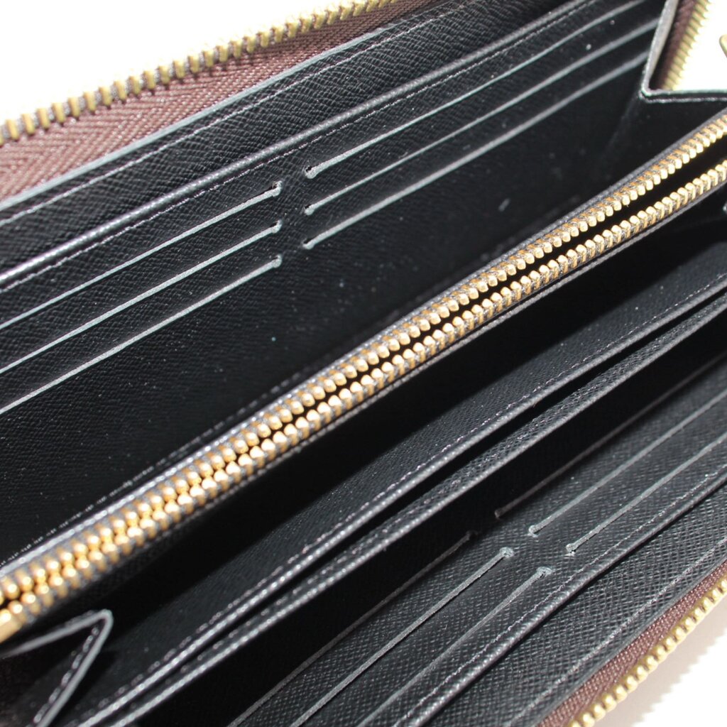 Black interior card slots of monogram zip wallet with gold zipper trim