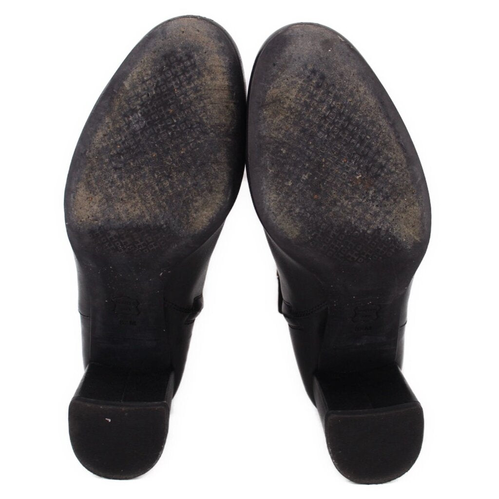 Black leather ankle boot pair outsole view with dark rubber heel tread.