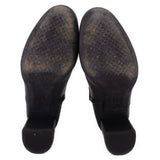 Black leather ankle boot pair outsole view with dark rubber heel tread.