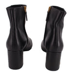Black leather ankle boot pair, back view of short heel and side zipper.
