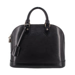 Black structured leather dome top-handle bag with front straps and top zipper hardware.