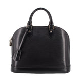 Black structured leather dome top-handle bag with front straps and top zipper hardware.