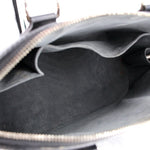 Black bag interior with gray fabric lining and open zipper at the top edge.
