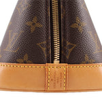 Monogram bag zipper close-up with tan leather pull and Louis Vuitton label
