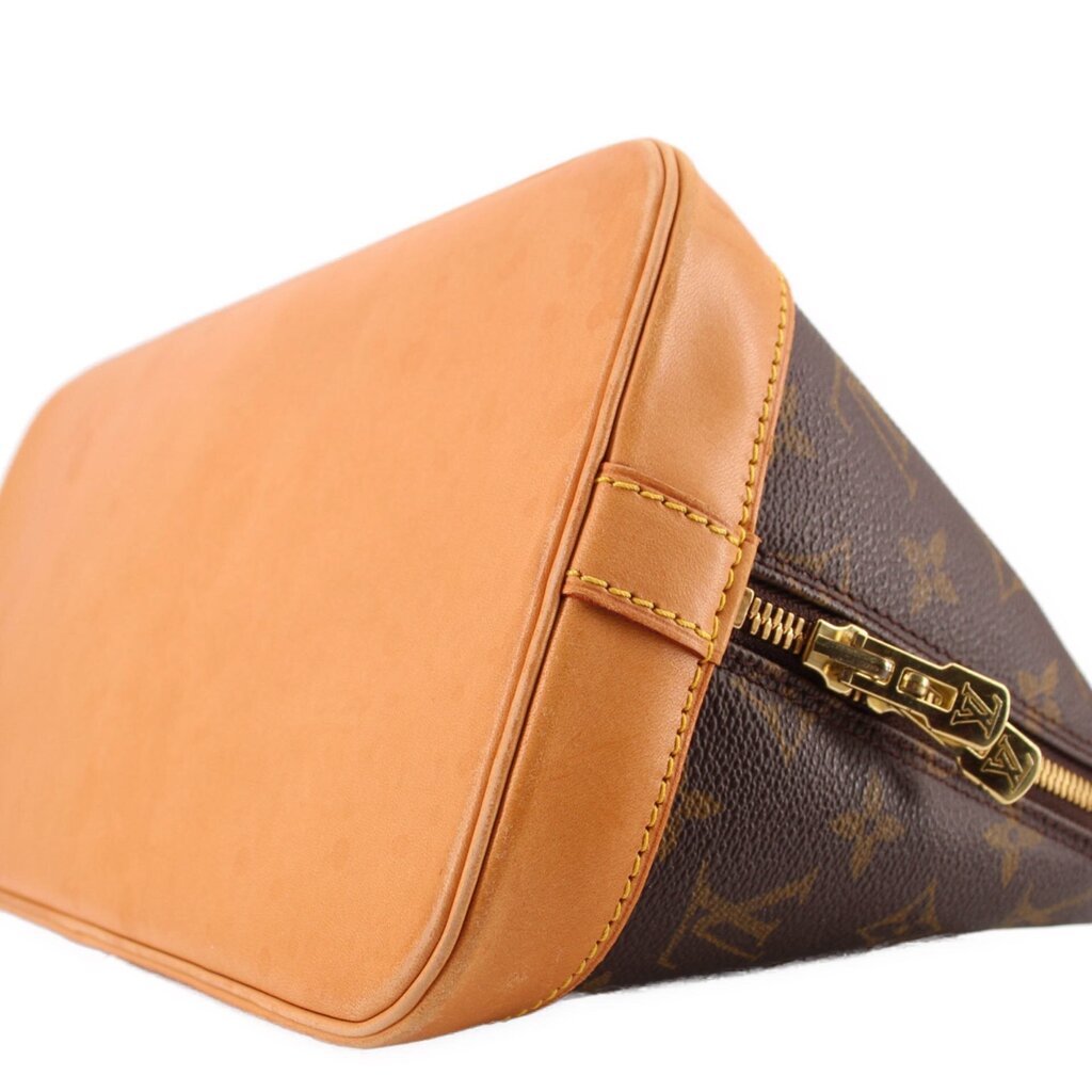 Monogram bag side close-up with tan leather flap and gold-tone zipper pulls