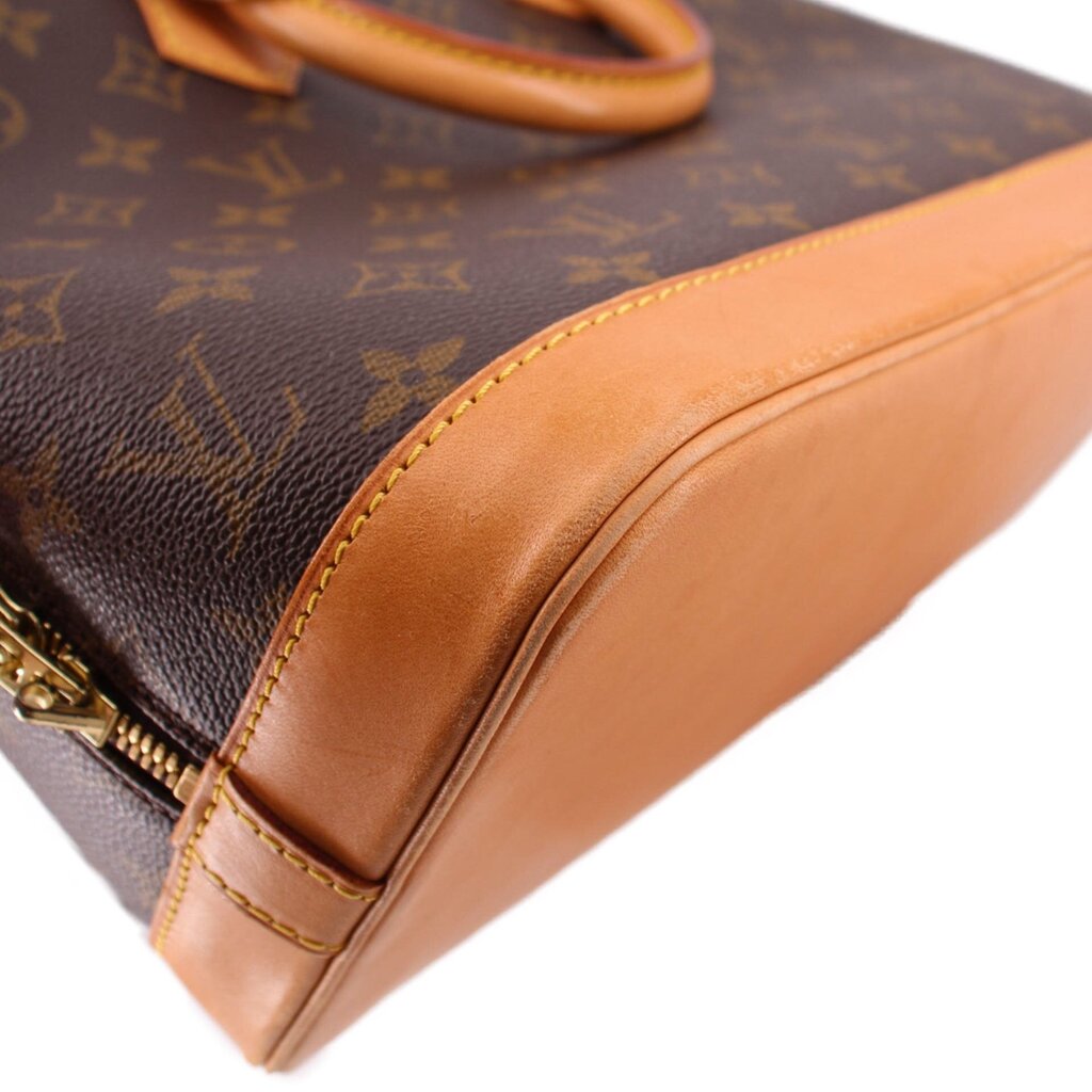 Monogram bag corner close-up with tan leather trim and stitched edge piping