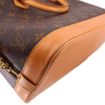 Monogram bag corner close-up with tan leather trim and stitched edge piping