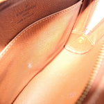 Louis Vuitton Orsay clutch interior close-up with snap tab and tan textured lining