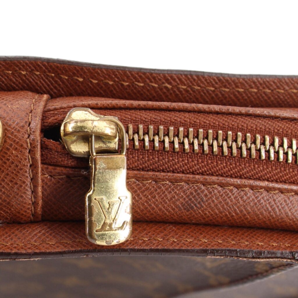 Louis Vuitton Orsay monogram clutch close-up of gold zipper pull with LV emblem