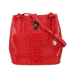 Red croc-embossed bucket shoulder bag with drawstring closure and metal charm tag