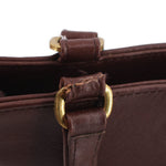 Close-up of worn, frayed leather at a brown shopper bag handle attachment