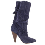 Side view of a navy suede slouch boot with wraparound straps and a tall tapered heel