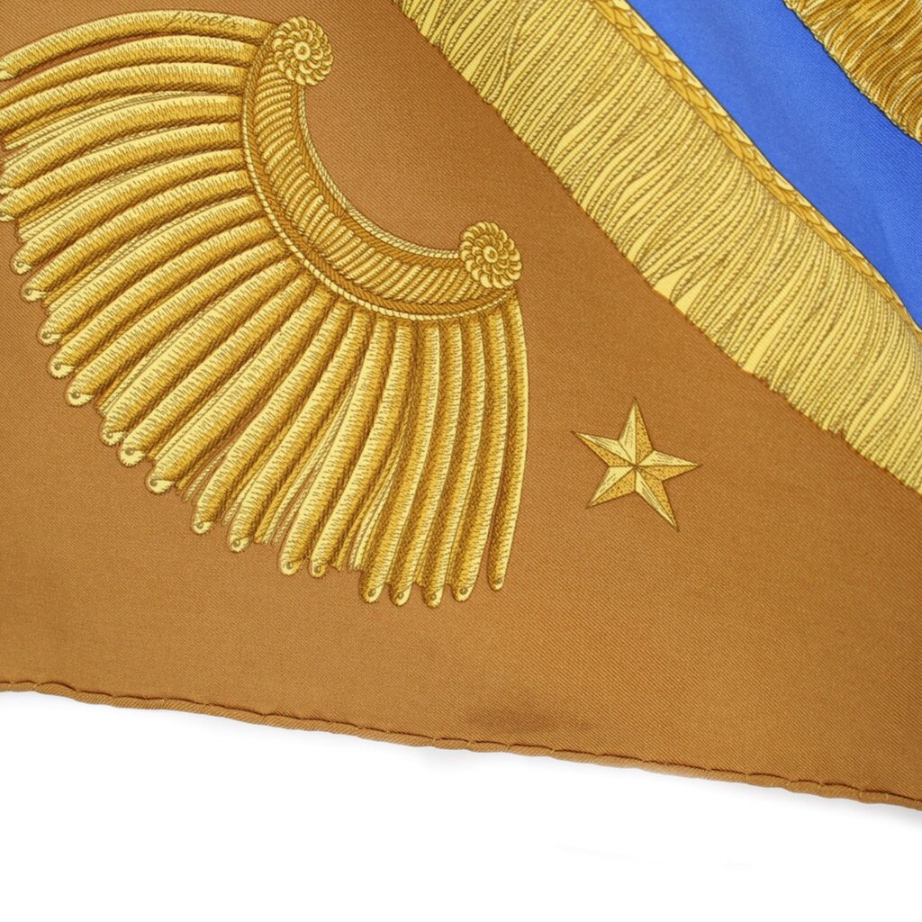 Brown HERMES silk scarf closeup: gold fringe border and star detail
