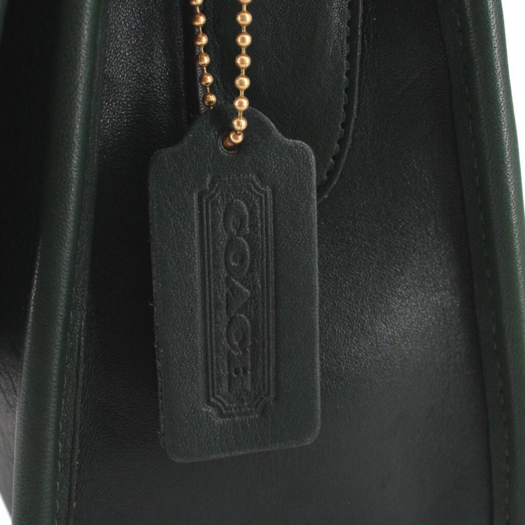 Close-up of the COACH leather hangtag with gold-tone ball chain