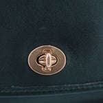 COACH vintage City shoulder bag close-up of gold-tone turn-lock clasp on dark green leather