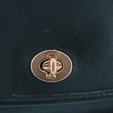 COACH vintage City shoulder bag close-up of gold-tone turn-lock clasp on dark green leather