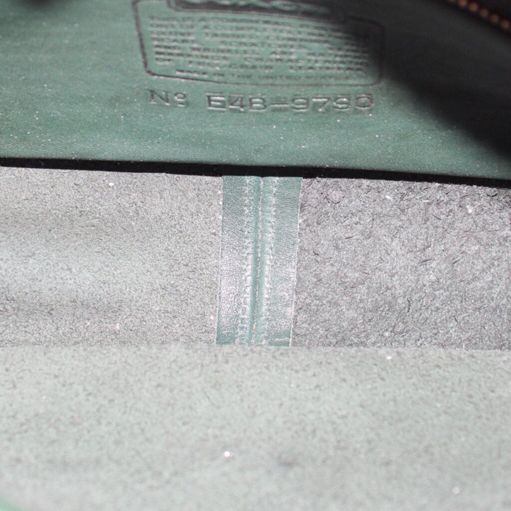 Interior of the COACH shoulder bag showing its lining and leather stamp