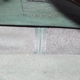 Interior of the COACH shoulder bag showing its lining and leather stamp