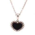 Close-up of the necklace's black heart pendant with a beaded silver-tone border