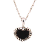 Close-up of the necklace's black heart pendant with a beaded silver-tone border