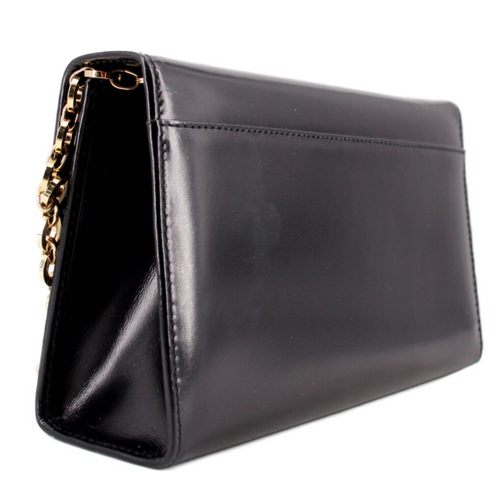 Black leather crossbody bag angled view with gold clasp and chain strap