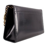 Black leather crossbody bag angled view with gold clasp and chain strap