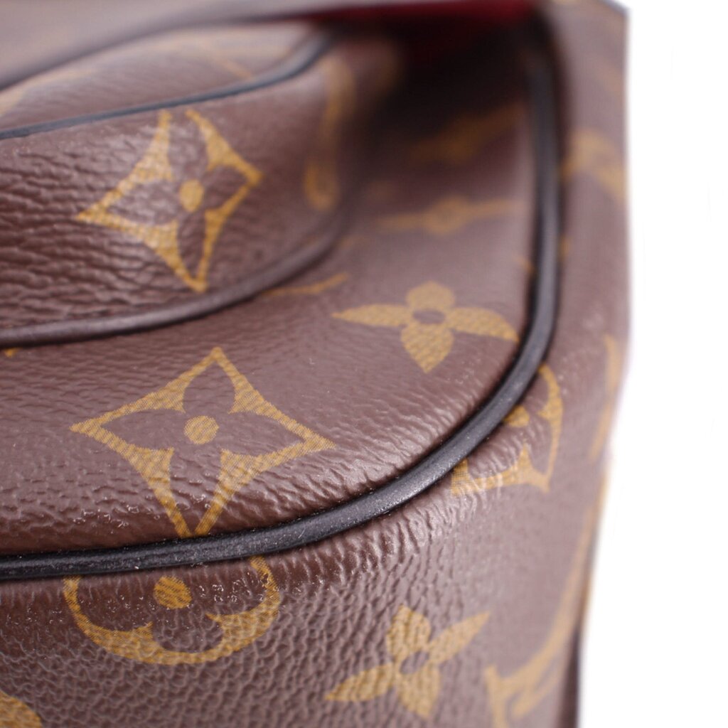 Close-up of brown monogram leather with curved flap trim and stitched edge