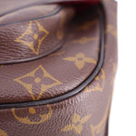 Close-up of brown monogram leather with curved flap trim and stitched edge