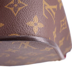 Close-up of brown monogram bag corner with rounded edge and thin piping