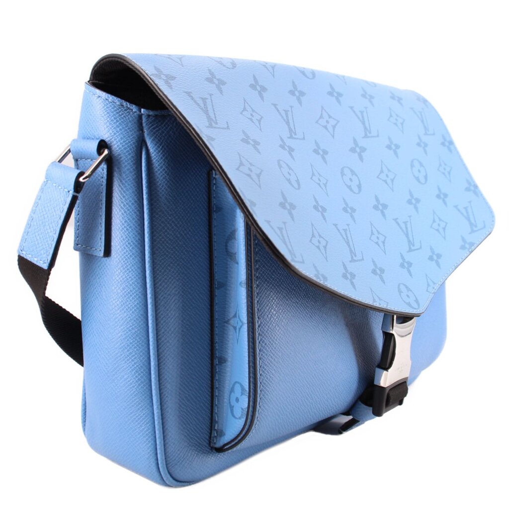 Blue crossbody bag with monogram flap, adjustable strap, and side pocket