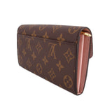 LOUIS VUITTON Sarah wallet, side view: brown monogram canvas with pink interior