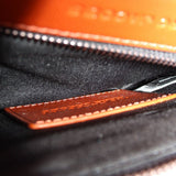 Close-up of rust leather bag zipper and interior lining with stitch detail