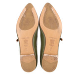 Leather soles of green flats with tan heel patches and printed size markings