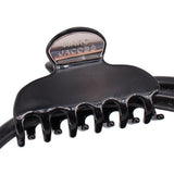Close-up of black claw clip handle with MARC JACOBS metal plaque