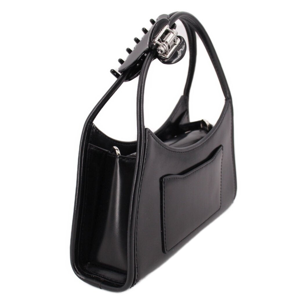 Black bag side view showing the gusset, patch pocket, and claw clip handle