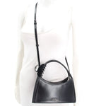 MARC JACOBS black crossbody bag worn with its adjustable long strap